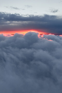 Dramatic red sunset over a sea of clouds