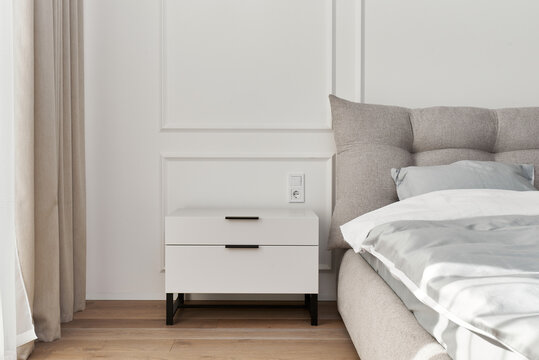 Modern Minimalist Bedroom Interior with White Bedside Table and Soft Gray Bed