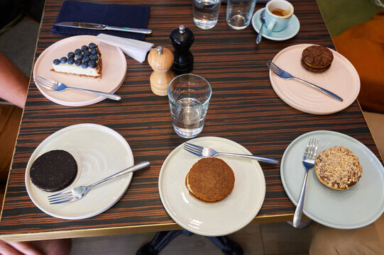 Top View Table Setting with Various Desserts, Coffee and Water in Cafe