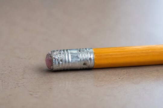 Close-up of a well-used yellow pencil with a worn pink eraser