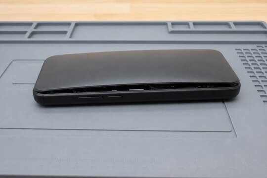 Smartphone with swollen battery causing the back cover to bulge and separate