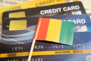 Obraz premium Guinea flag on credit card, finance economy trading shopping online business.