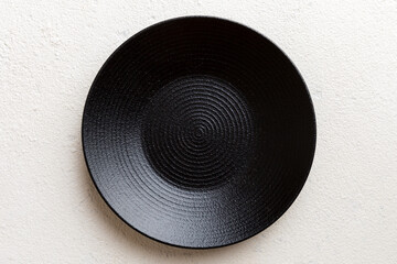Top view of black plate on cement background. Empty space for your design