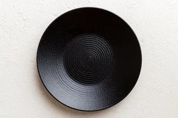 Top view of black plate on cement background. Empty space for your design © sosiukin
