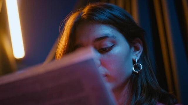 Young Caucasian woman reading theater script intently during acting rehearsal in close up shot. Clip suitable for drama education, stage production marketing and creative arts campaigns