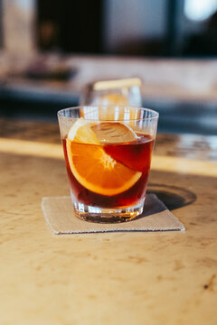 Elegant cocktail with citrus garnish served at a modern bar