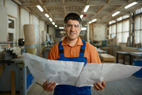 Plant supervisor evaluates production schematics and safety procedures diligently