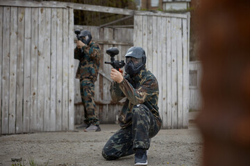 Obraz premium Soldiers are taking positions during tactical weapon training, one aims while sitting on the ground