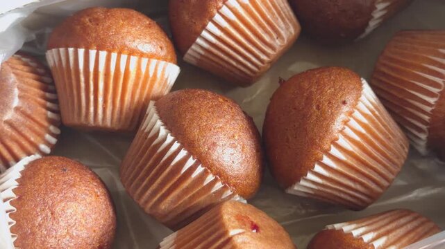 Golden muffins in paper liners fill the surface next to each other