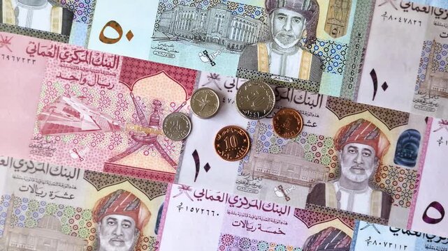 Oman, omani paper money, rial or riyal banknotes and baisa coins as currency for exchange or travel. Omani money as a business background