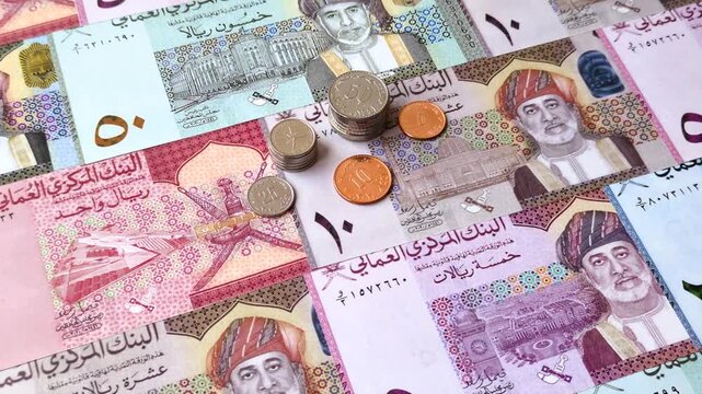 Oman, omani paper money, rial or riyal banknotes and baisa coins as currency for exchange or travel. Omani money as a business background