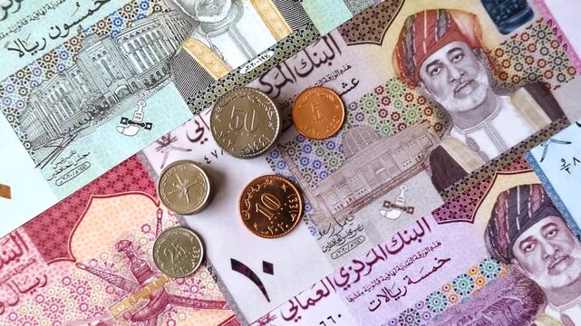 Oman, omani paper money, rial or riyal banknotes and baisa coins as currency for exchange or travel. Omani money as a business background