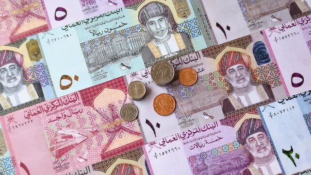 Oman, omani paper money, rial or riyal banknotes and baisa coins as currency for exchange or travel. Omani money as a business background