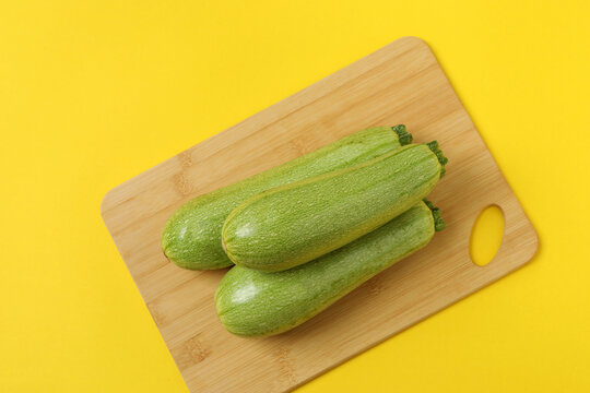 Zucchini on a colored background. Organic vegetarian vegetables. Healthy food. Negative space. Space for text. Healthy eating concept.
