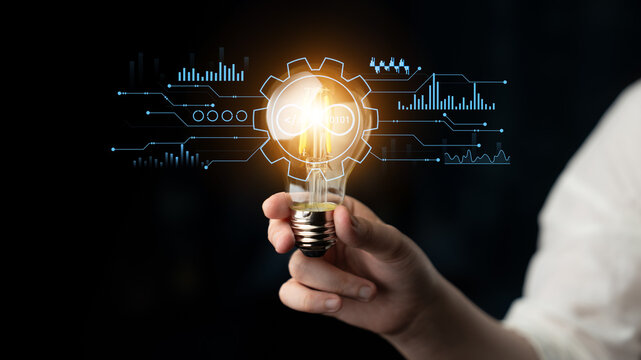Hand Holding Light Bulb with Future Technology Concept in Background Showing Digital Interface and Innovation Ideas for Creative Solutions. Entropy.