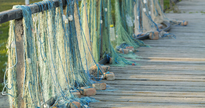 Detail of fishing nets drying on wooden fence of the pontoon