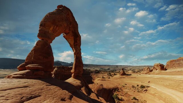 Time lapse of clouds moving over Delicate Arch in Arches National Park, Utah, with red rock desert.