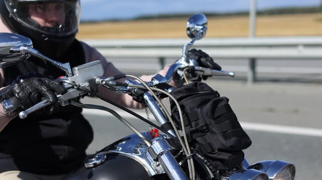 This exhilarating slow motion footage showcases a motorcyclist navigating through headwinds effortlessly on an asphalt road. The freedom of the open road invites the spirit of adventure