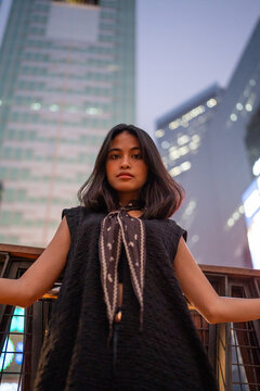 Young woman urban fashion looking at camera at night