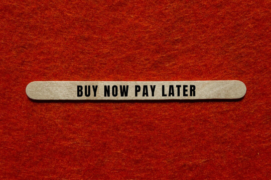Buy now pay later message on a wooden stick conveying modern payment options, credit, loan and financial planning concepts
