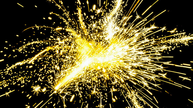 Brilliant gold glowing firework sparks exploding forcefully outward against solid black background creating dynamic bright fiery abstract texture during nighttime celebration