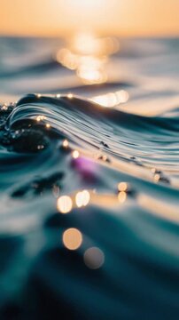Close up of shimmering ocean water waves with golden sunlight reflections during sunset