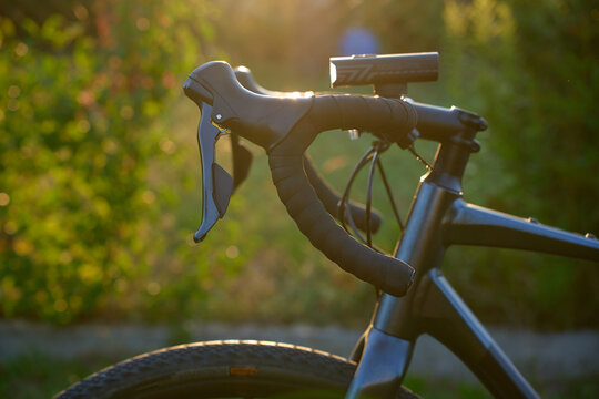 Close up of gravel bike handlebars with front light at sunset