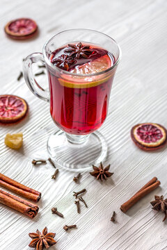 mulled wine with spices in cup on wooden background