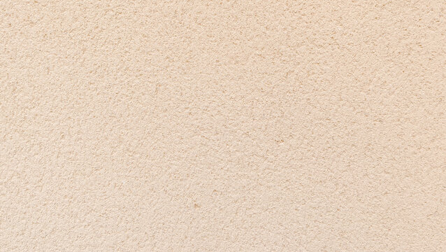 Light beige fine textured sandstone plaster wall surface background with uniform grain