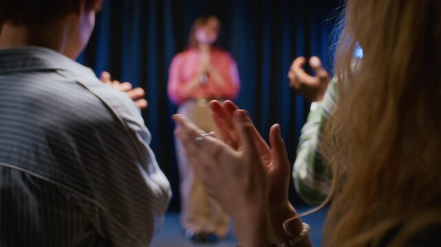 Teenage students applauding actress bowing on stage after performance, rear view. Useful for advertising drama schools, acting workshops, or creative arts education