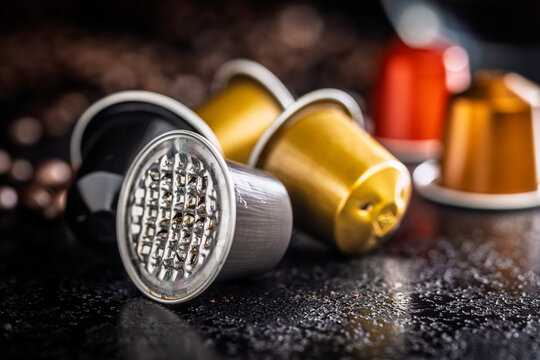 Used Coffee Capsules and Roasted Beans on Dark Textured Surface for Espresso Brewing