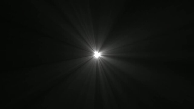 Abstract bright white light flare with radial rays emanating from center on a solid black background