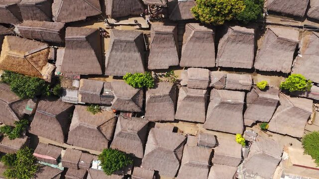 Top-down drone view of Sade Traditional Village in Lombok, Indonesia, revealing dense Sasak thatched homes, narrow lanes and an intricate organic roof pattern.