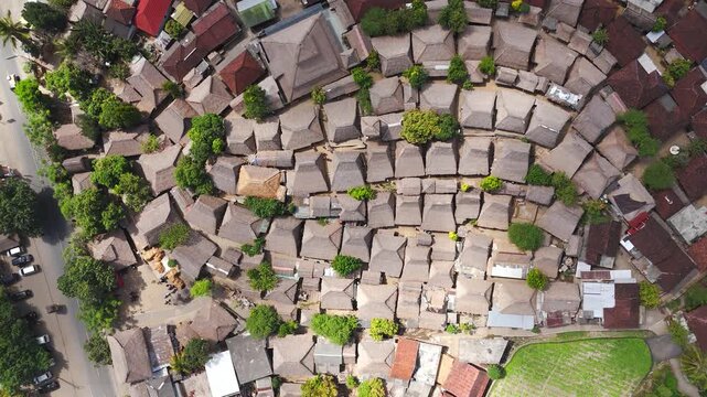 Sade Traditional Village in Lombok, Indonesia, showing dense Sasak thatched-roof houses and rural travels, cinematic top-down view