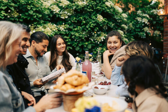Diverse family members sharing happy moment during outdoor birthday lunch