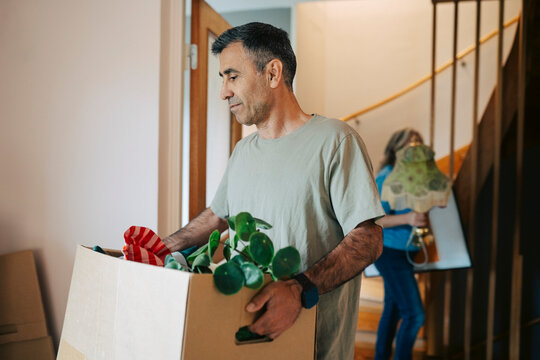 Couple relocating and bringing belongings inside their apartment