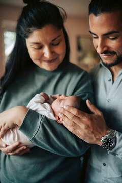 Smiling parents admiring their newborn child at home