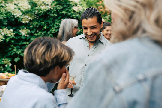 Happy man laughing during outdoor family gathering in back yard