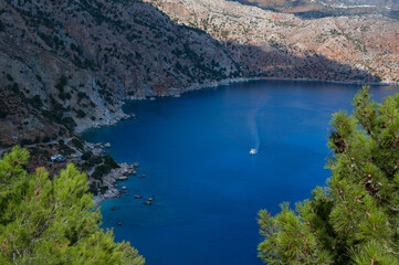 Apella Beach on Karpathos is a stunning crescent-shaped cove known for its striking white pebbles, pine backdrop, and vivid turquoise waters © mtphoto19