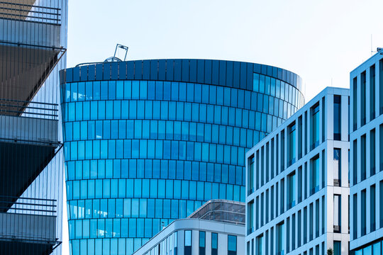 Blue curved office architecture with modern glass windows and layered facades creates a compact urban scene of contemporary business buildings
