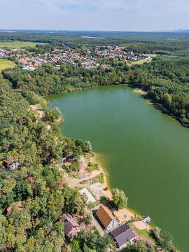 Aerial view of the Pieskovna lake surrounded by dense forest and the village of Plavecky Stvrtok, Plavecky Stvrtok, Bratislava Region, Slovakia.