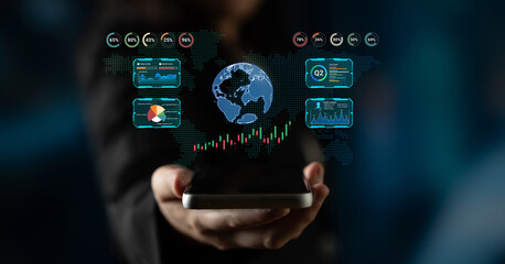 Obraz premium Business person holding smartphone with digital analytics data and globe graphics, showcasing data analysis and technology innovation in modern context. Sentient.