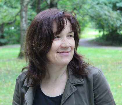 Serene Mature Woman Smiling in Green Park with Copy Space.

