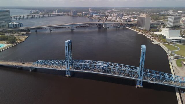 Aerial view of Jacksonville's Main Street Bridge over the St. Johns River with downtown buildings, waterfront parks, and multiple river crossings