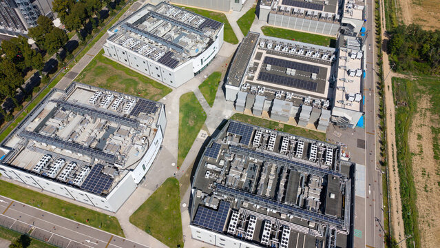 Aerial view of the DATA4 MILAN CAMPUS featuring modern data center buildings with solar panels on rooftops, cooling units, and surrounding paved pathways in Zona Industriale, Lombardia, Italy.
