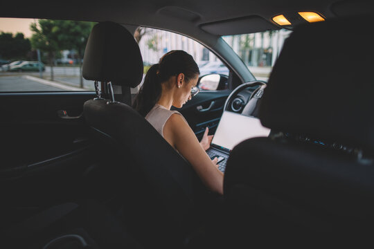 Businesswoman working remote from a parked car