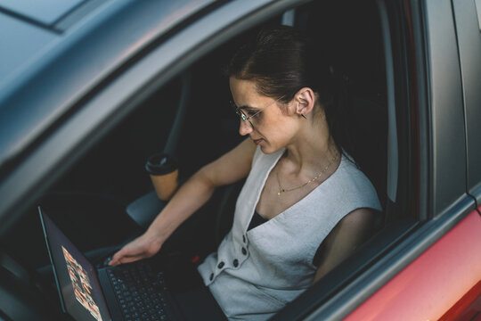Remote work after hours, businesswoman working from a parked car