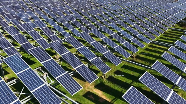 rows of solar panels on green grass field