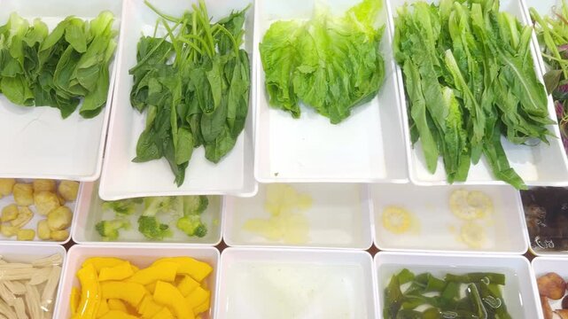 Fresh Greens and Assorted Mushrooms for Wok and Hot Pot on Display in Chinese Restaurant &ndash; Leafy Vegetables, Enoki, Shitake and Oyster Mushrooms