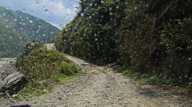 Rasuwa, Bagmati Province, Nepal - 07 May 2026: View of a rugged, unpaved mountain road winding through steep slopes near the Rasuwagadhi border crossing.